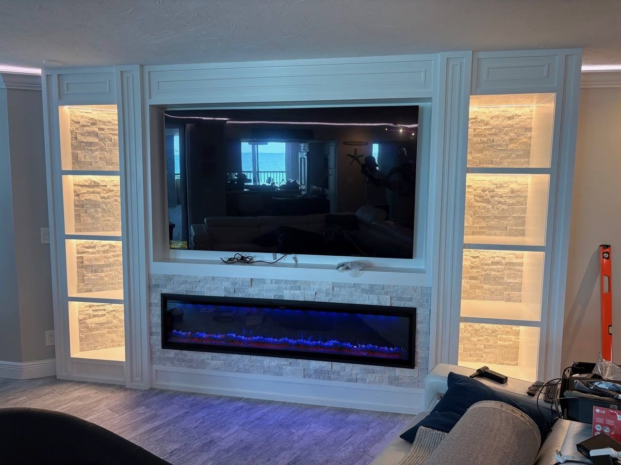 Modern built-in entertainment center with stone finish and electric fireplace in Clearwater Beach FL