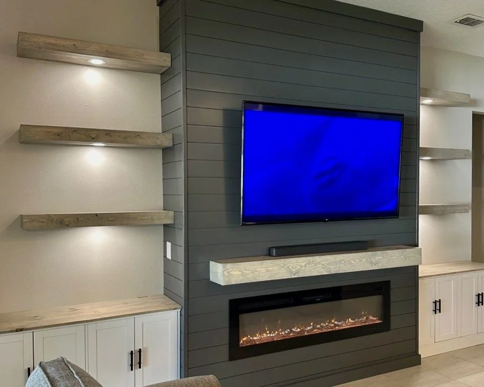 electric fireplace with floating wood mantel on shiplap media wall