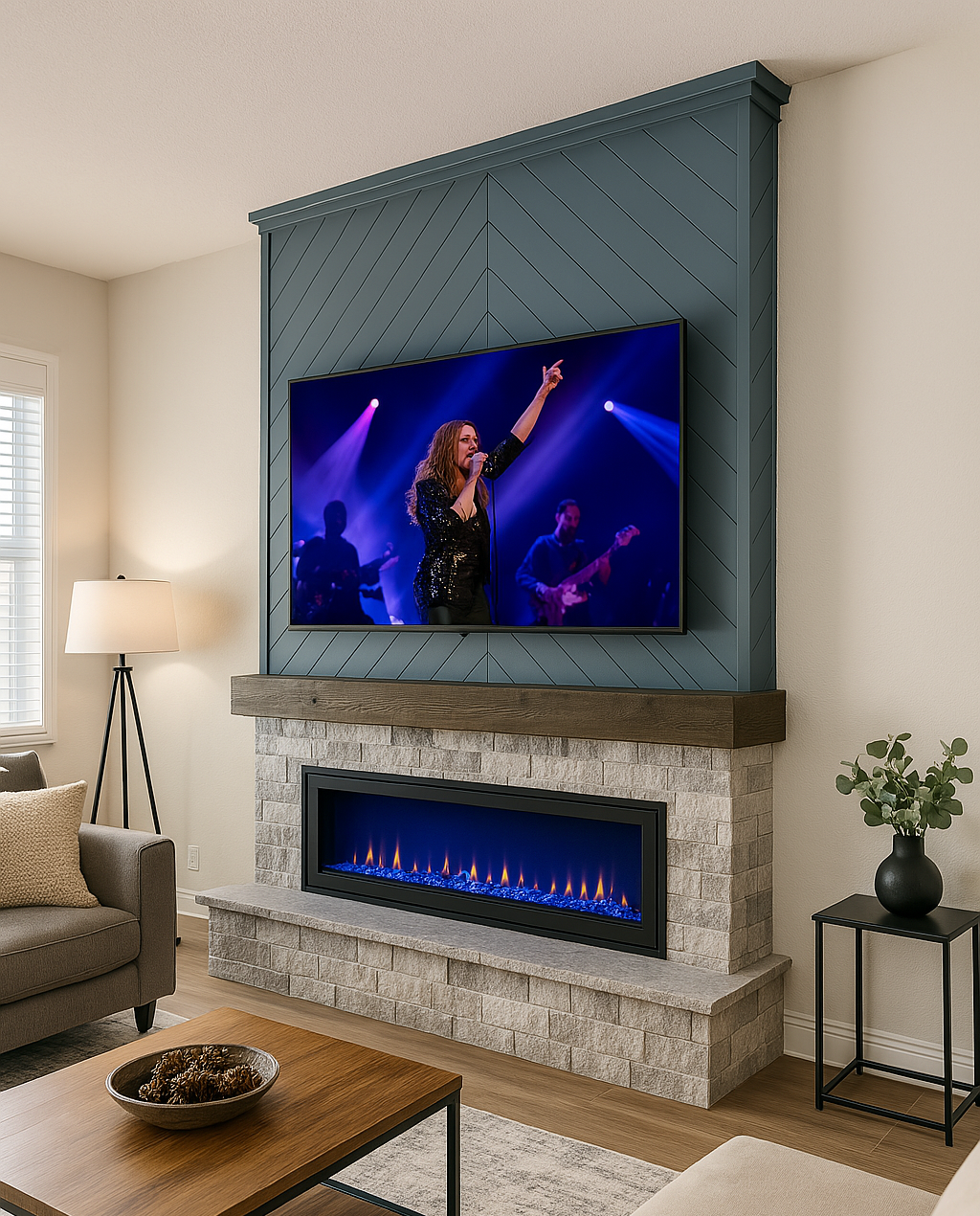 Living room with a gas fireplace, a TV mounted above it displaying a woman singing on stage, a beige sofa, a wooden coffee table with a decorative bowl, a side table with a black vase and green plant, and a floor lamp in the corner.
