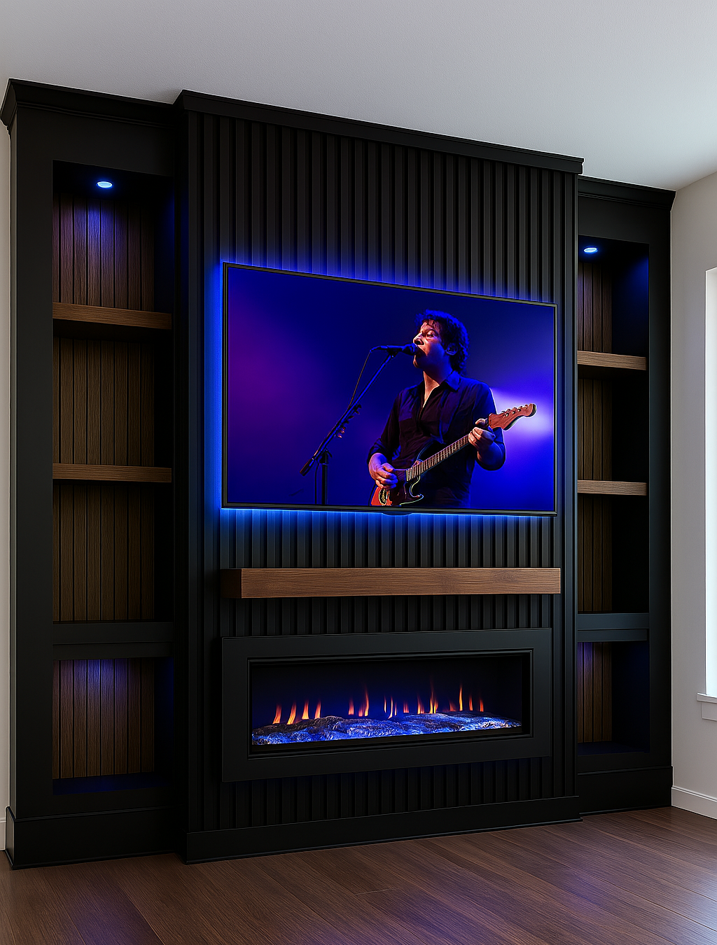 Flat-screen TV showing a musician playing an electric guitar and singing into a microphone, with a modern electric fireplace below and built-in shelves on either side, all in a living room with dark wood flooring.