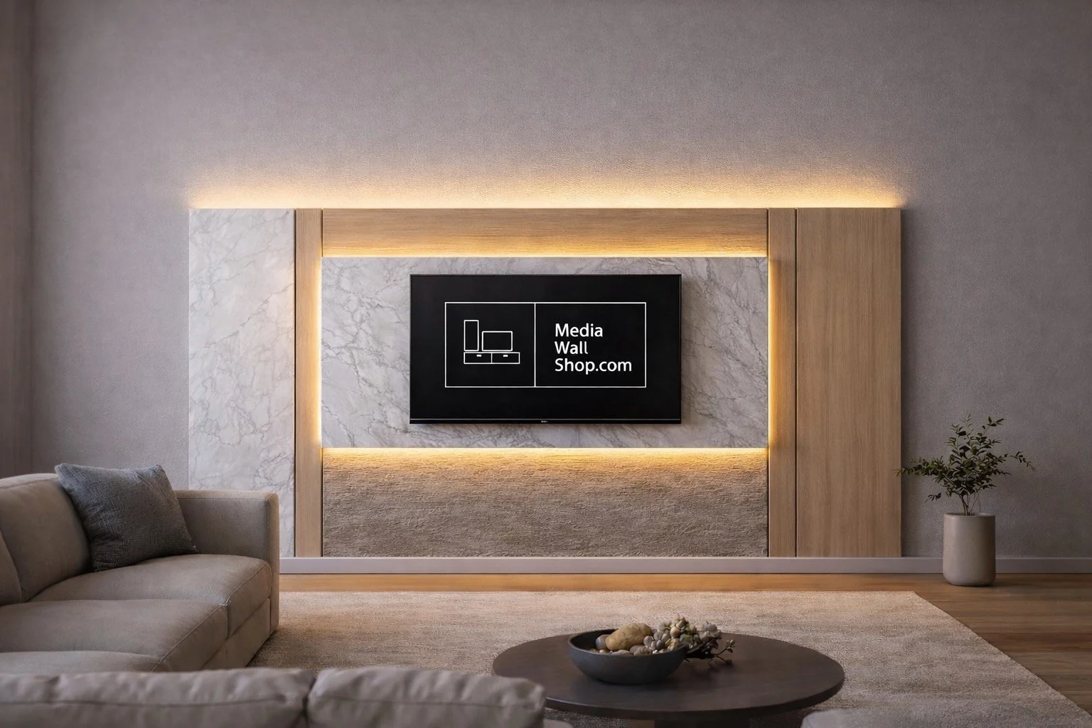 Modern living room with a TV displaying 'Media Wall Shop.com' mounted on a marble and wood accent wall, with a gray sofa and a coffee table with decorative stones.