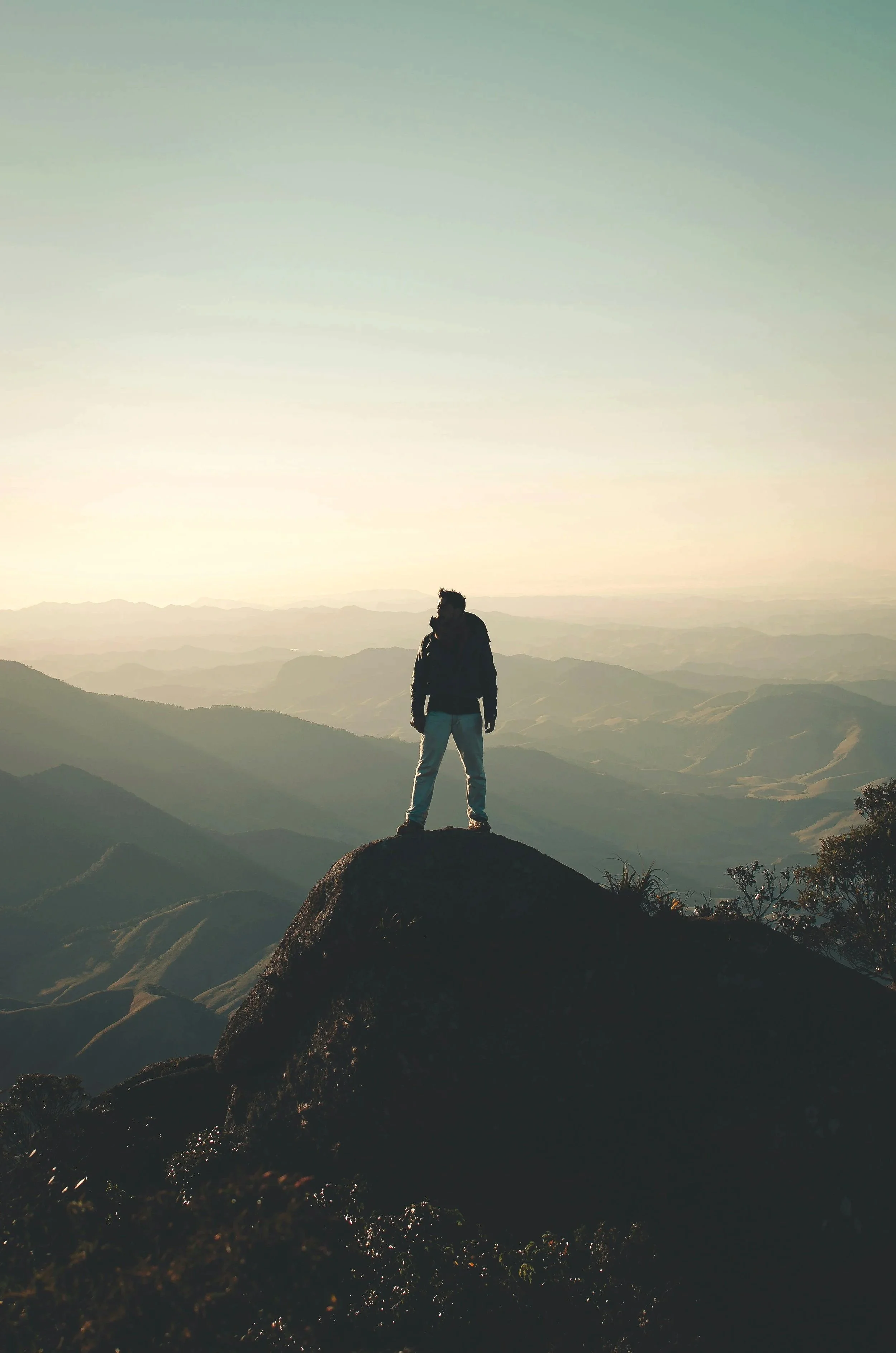 A man standing on top of the mountain above all of his competitors.