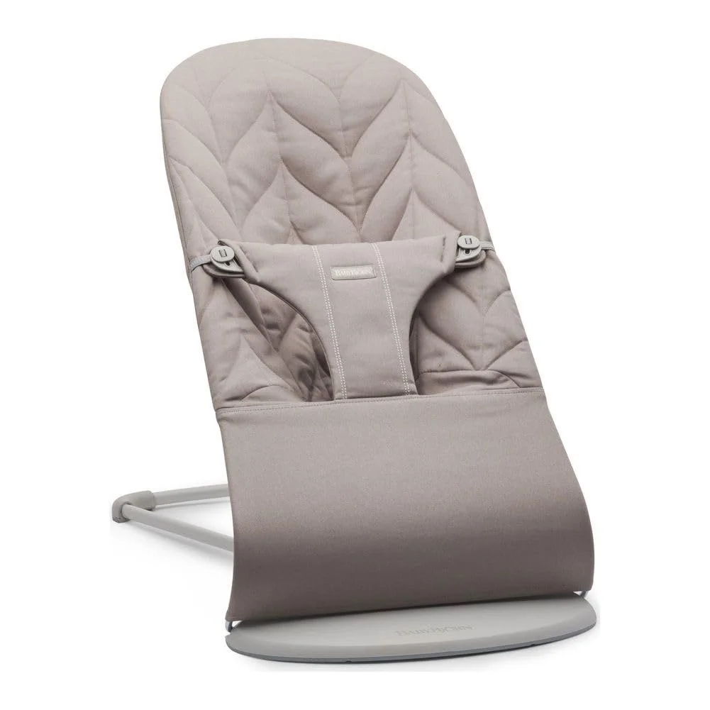 A beige baby bouncer chair with a padded seat and a safety harness, on a white background.