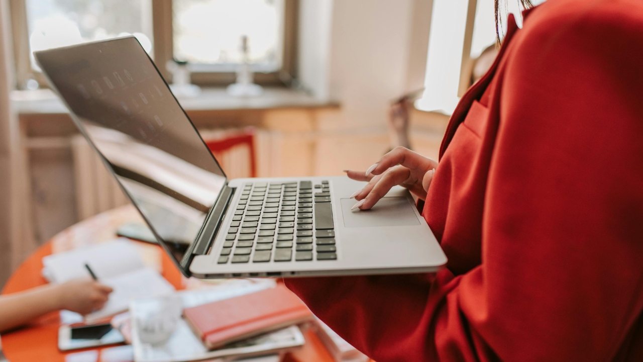 Photo of a businesswoman using a laptop by Vlada Karpovich https://www.pexels.com/photo/person-in-red-blazer-using-the-laptop-she-is-holding-8367777/