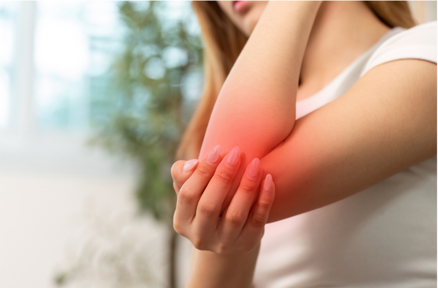 A female patient is holding her right elbow with her left hand. Her elbow is highlighted in red, indicating pain. The background is blurred, but appears to show trees. The text over the picture says "Tennis Elbow"