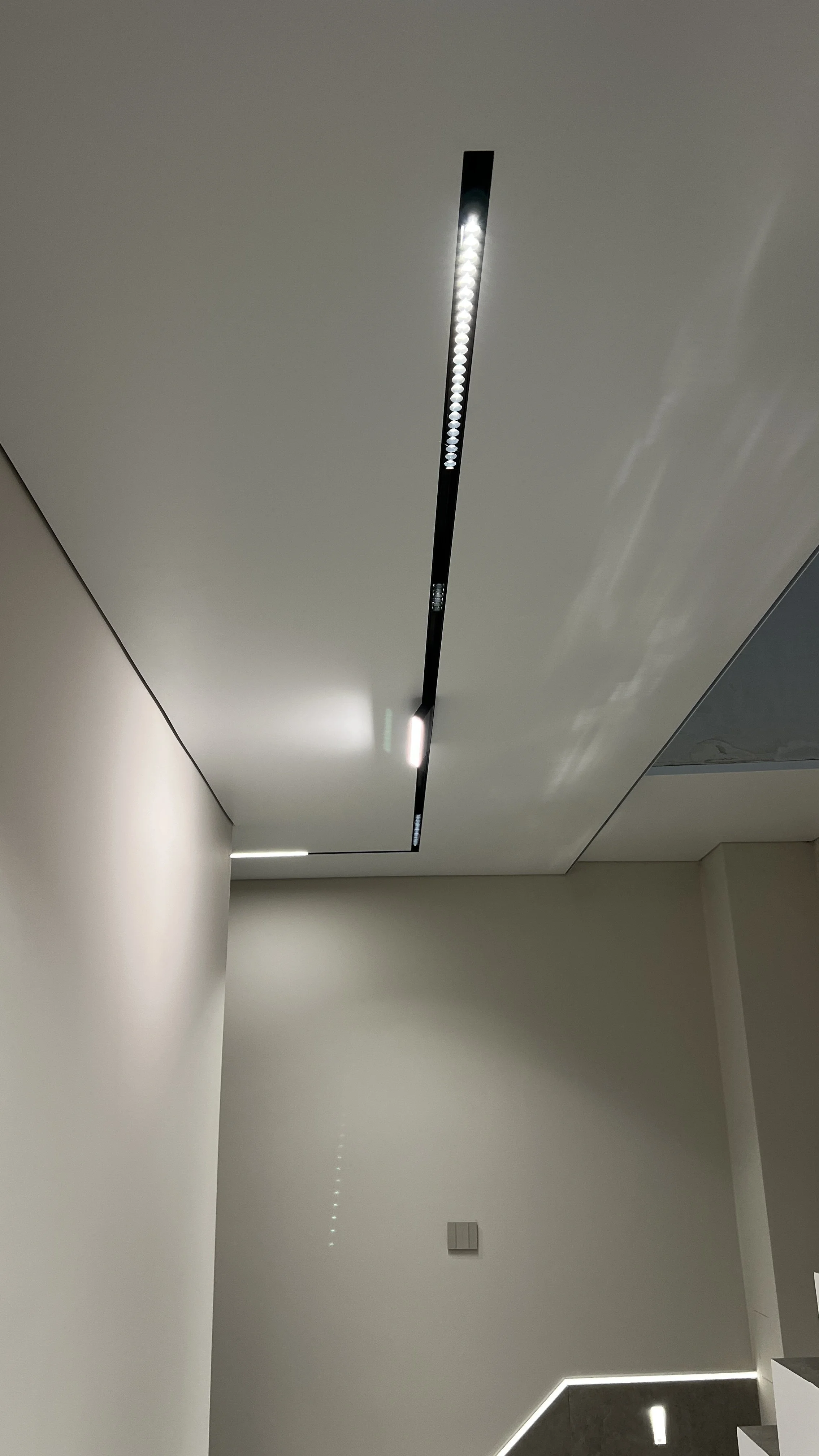 Бял матов таван тип опънат (окачен) със скрита гардина (карнизна ниша) и релсов трек – София.