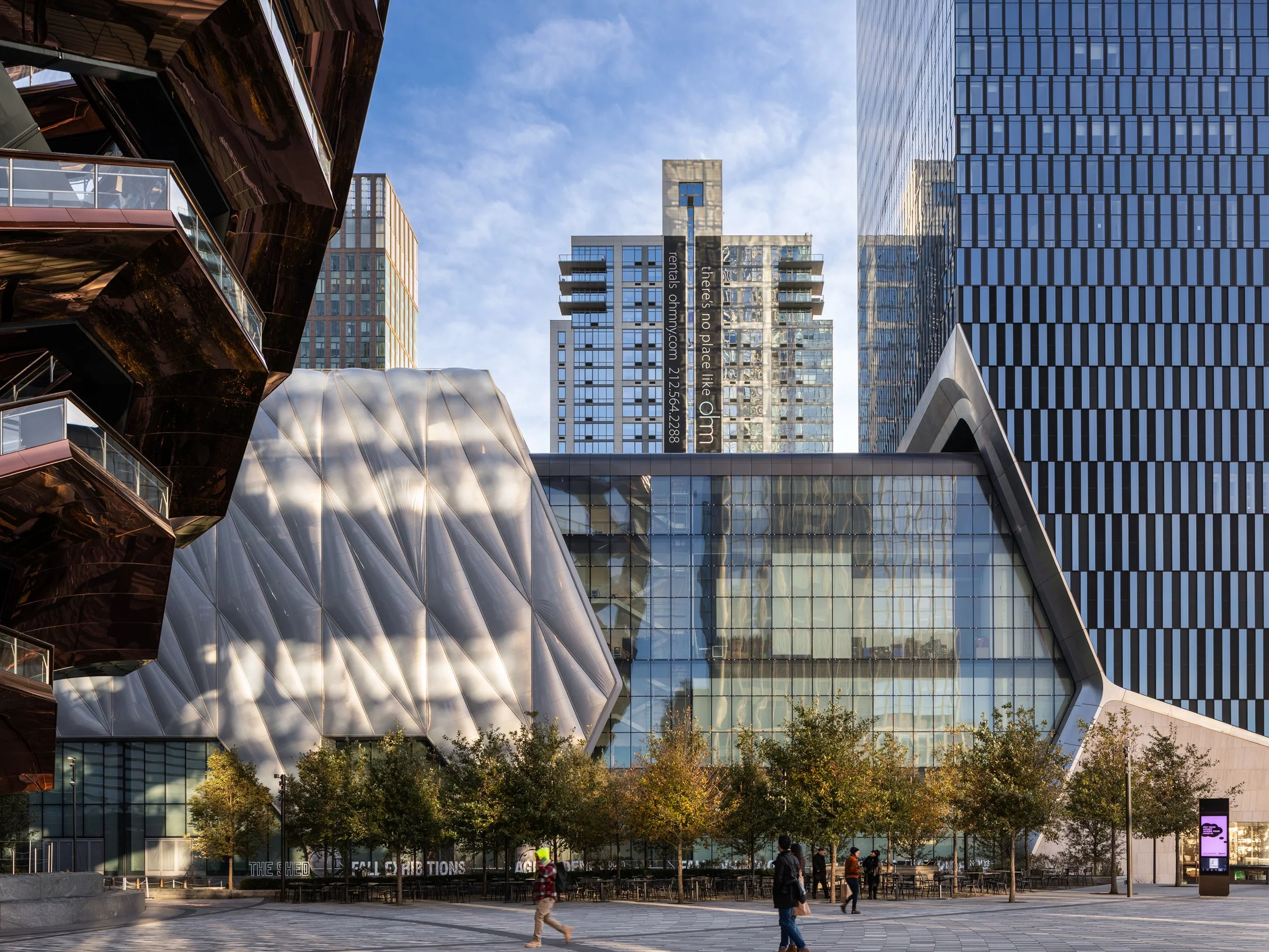 Modern cityscape with various architectural buildings, trees, and people walking.