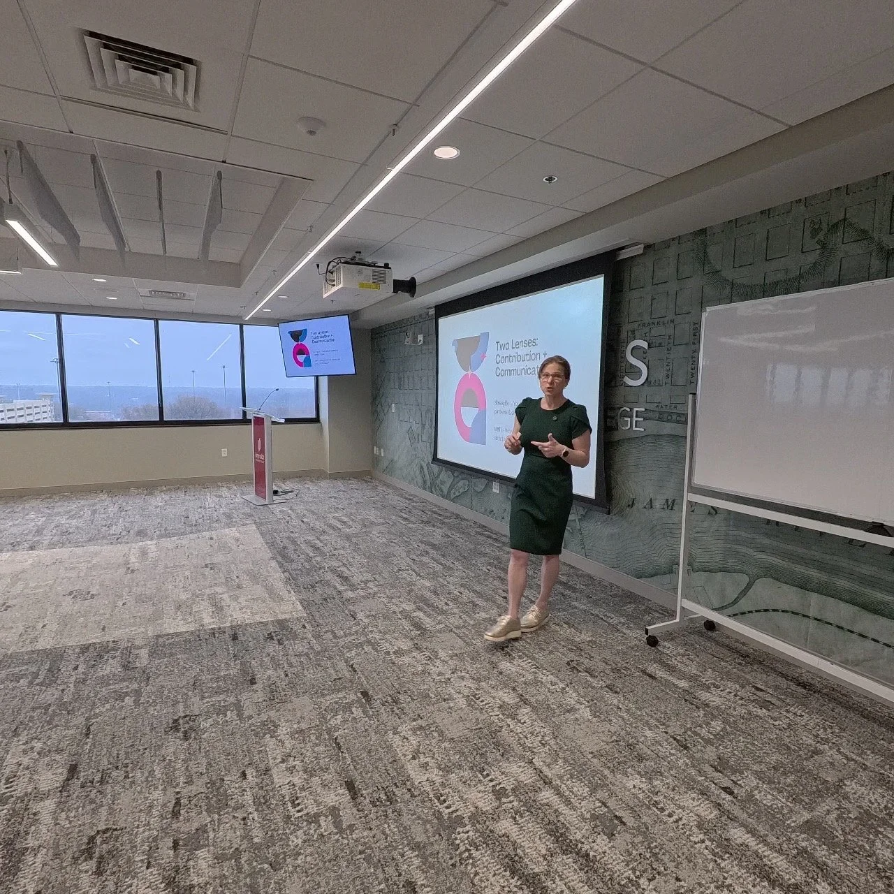 overhead shot of a university lecture hall that is full of students looking like they are listening to calss some students have laptops. out some have notebooks out