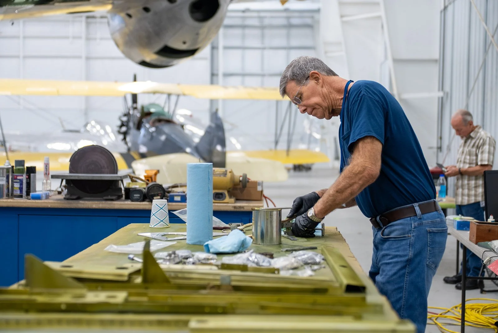 A restoration team member works on aircraft hardware at the workbench inside the First Air Force One restoration hangar in Bridgewater, Virginia