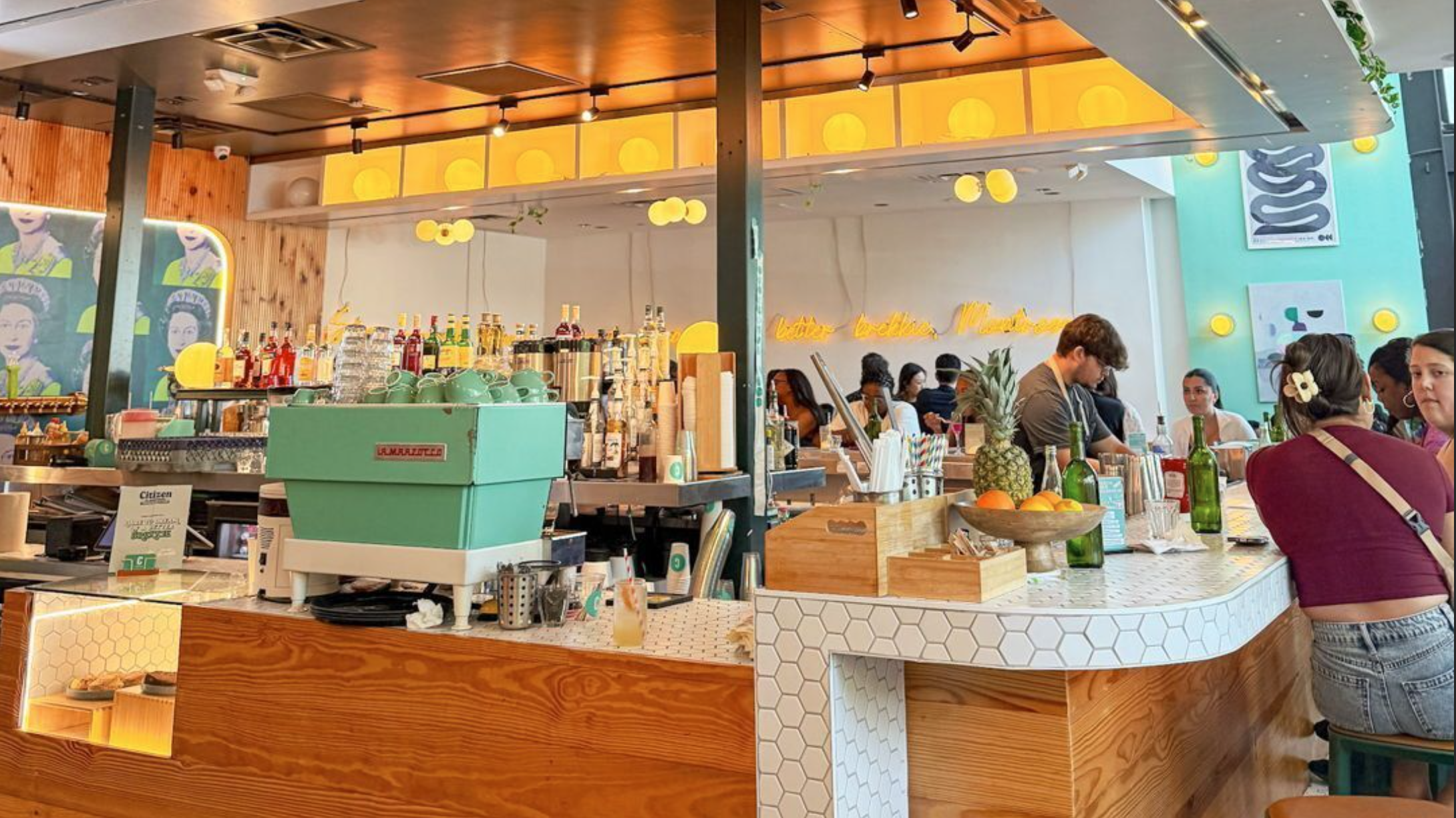Guests gathered around the bar of a colorful restaurant during service