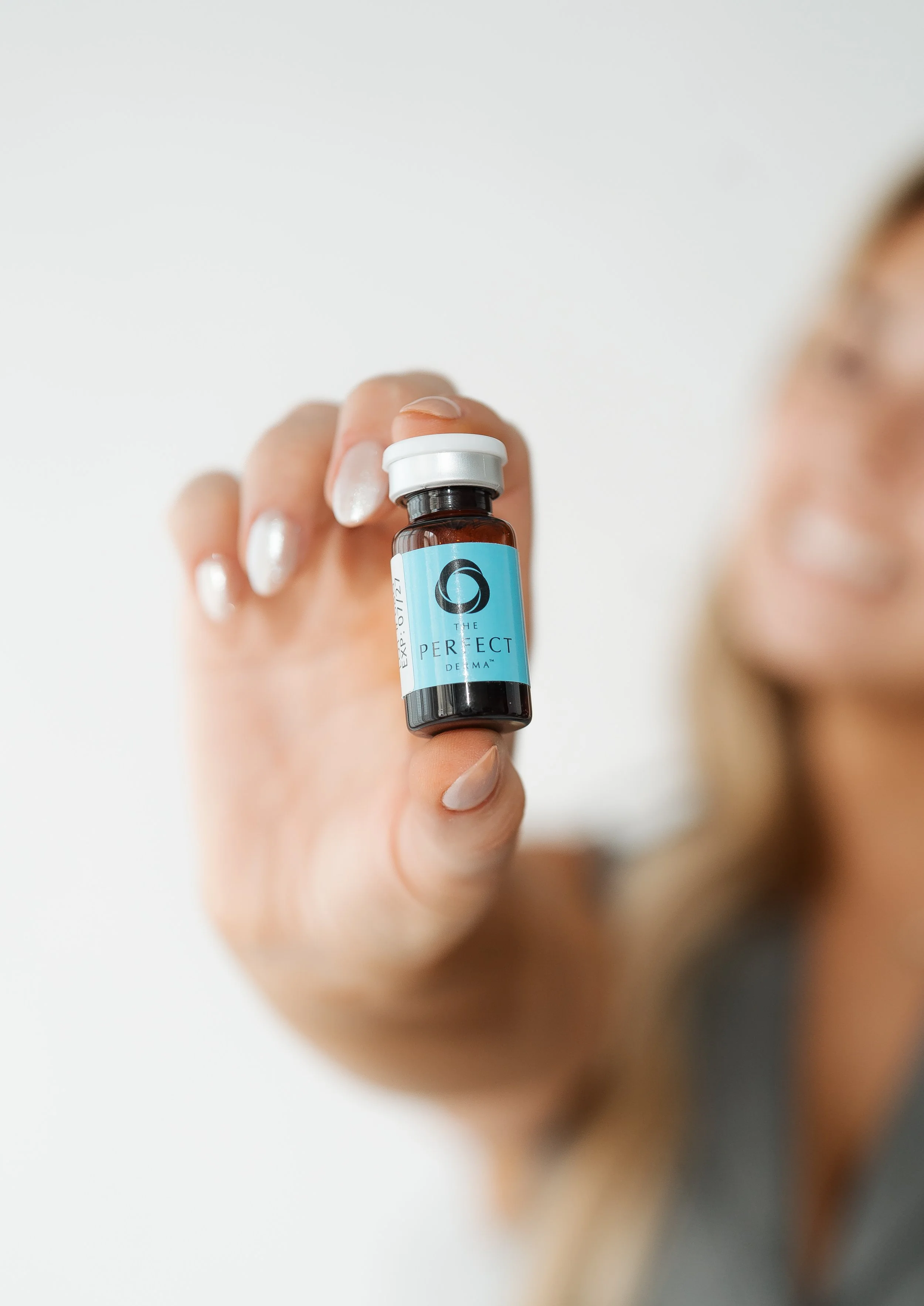 Hand holding The Perfect Derma Peel vial