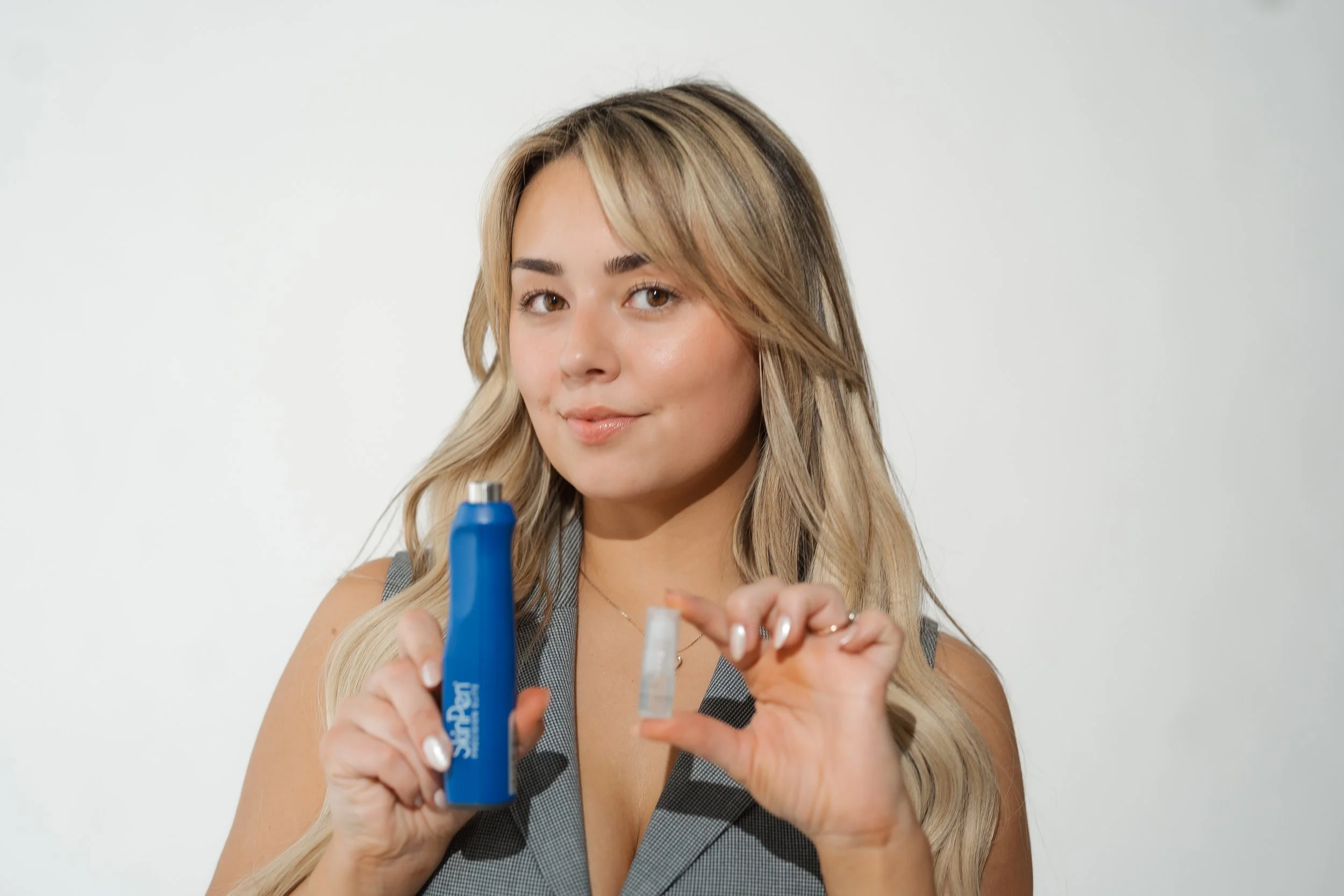 Mackenzie DeCovich, LME, holding a SkinPen microneedling device and needle cartridge