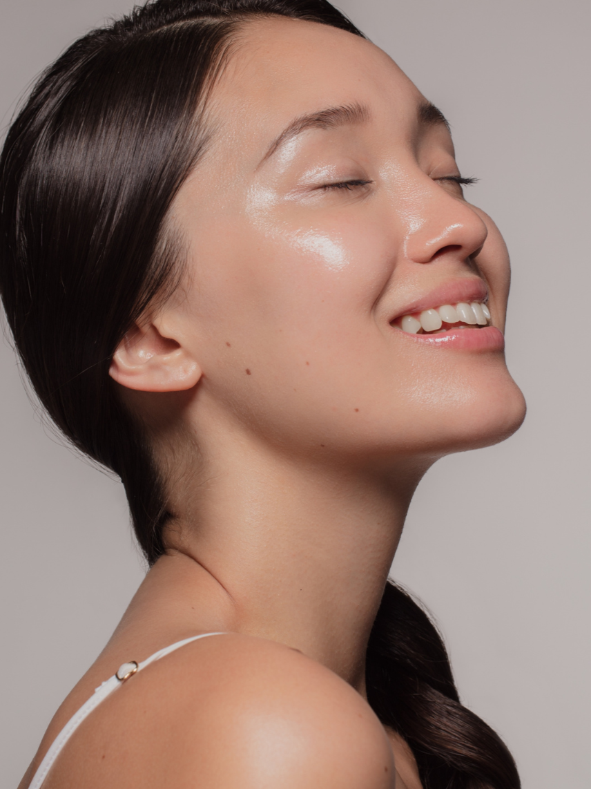 Woman with smooth, glowing skin smiling in profile