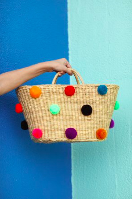 hand holding Nannacay pompom bag