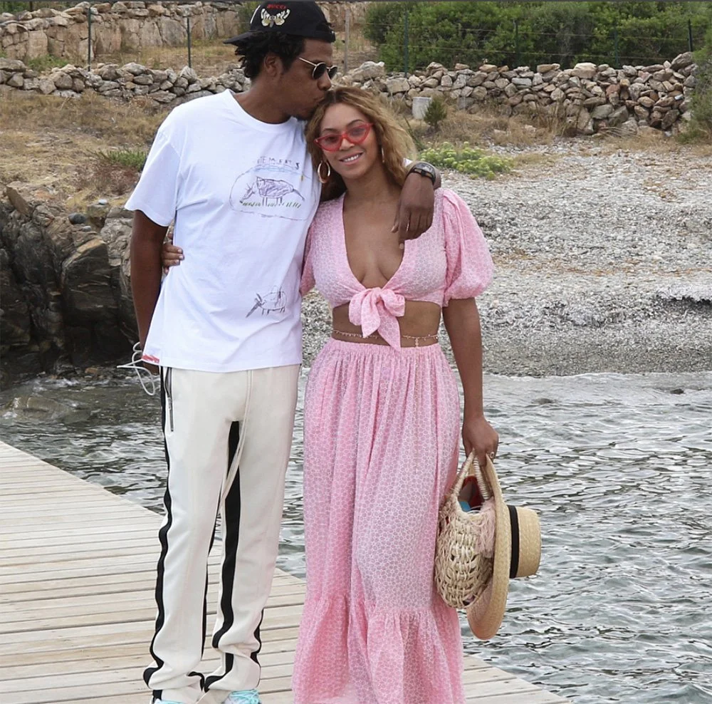 Jay Z kissing Beyonce who's carrying Nannacay woven bag in a pier