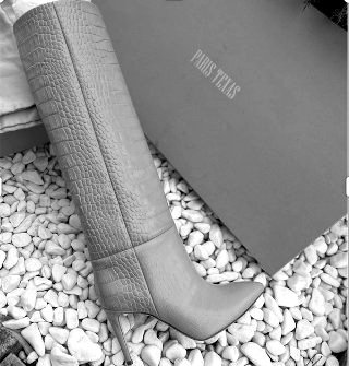 A pair of stilleto high boots next to a box saying Paris Texas