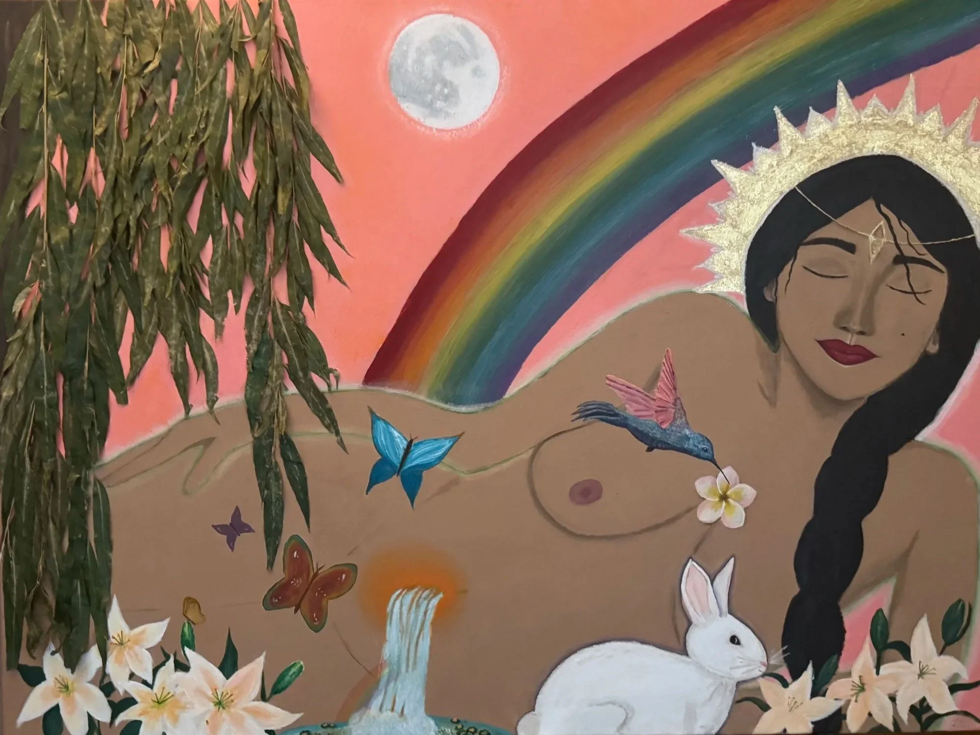 A mural depicting a woman with long black hair, a golden halo behind her head, closed eyes, and red lipstick, surrounded by a rainbow, a white bunny, colorful butterflies, a waterfall, flowers, and a full moon against a pink background.