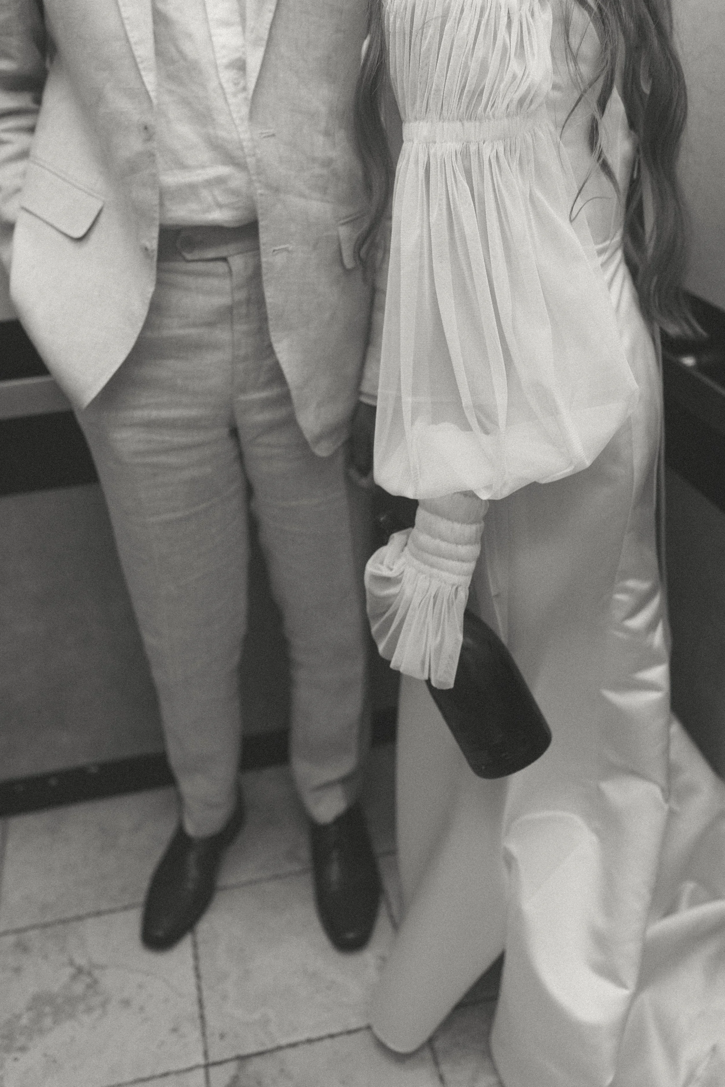 Bride and groom snuggling in an elevator as they head back down to their guest to celebrate at their reception. 