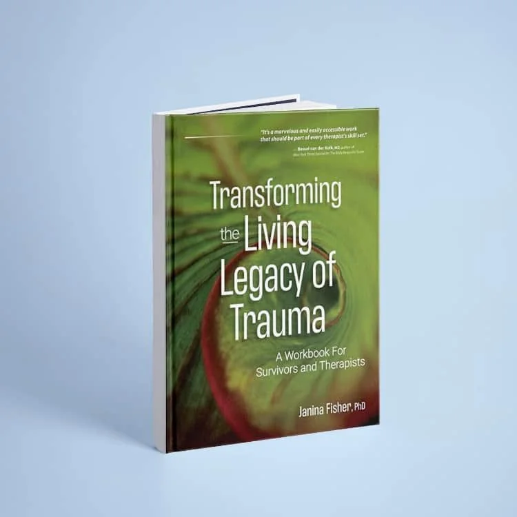 A book titled 'Transforming the Living Legacy of Trauma' by Janina Fisher, PhD, with a green and brown nature-themed cover, standing on a light blue background.