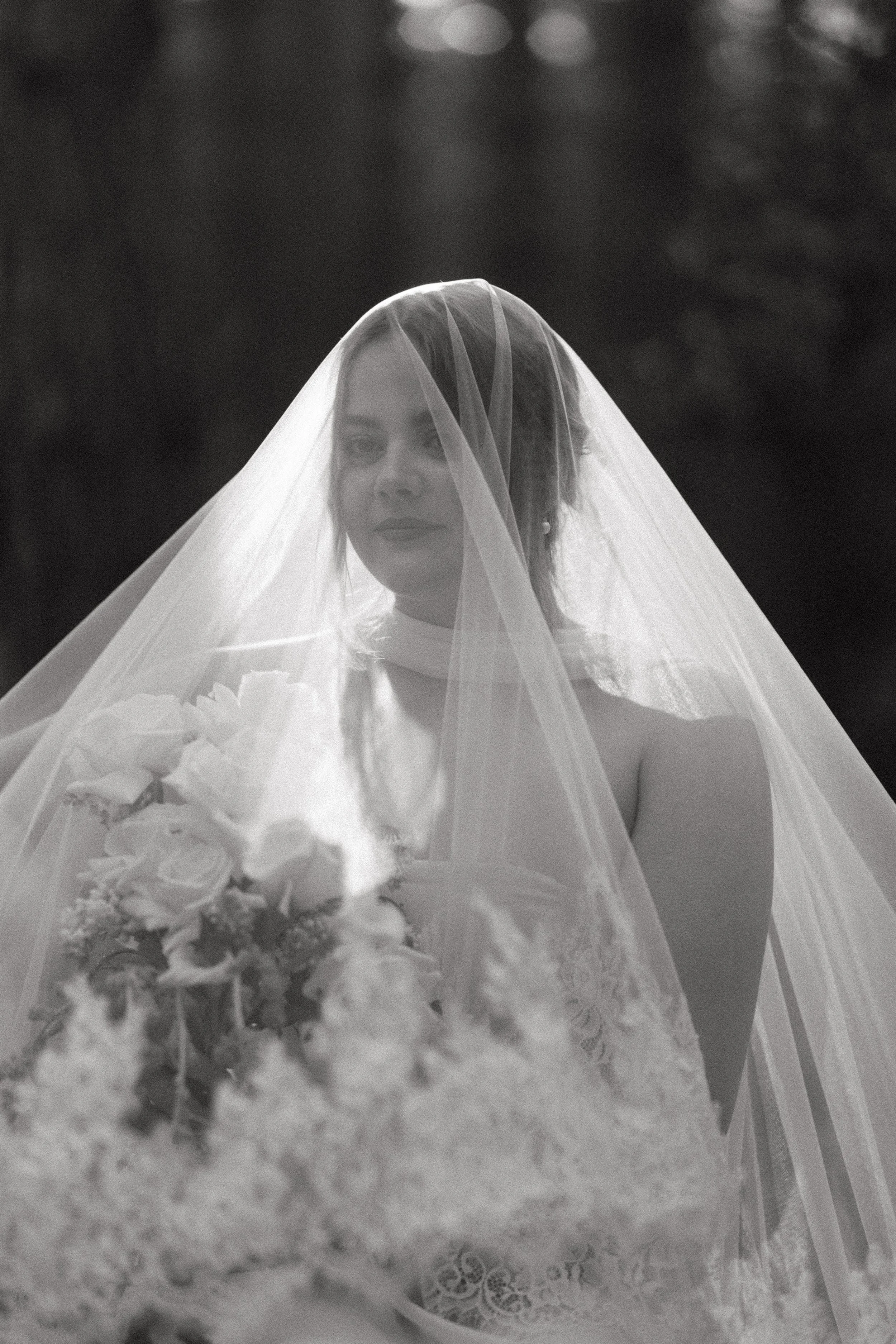 Editorial Luxury Black and white photo of a bride wearing a veil and holding a bouquet of flowers for a Norfolk Wedding