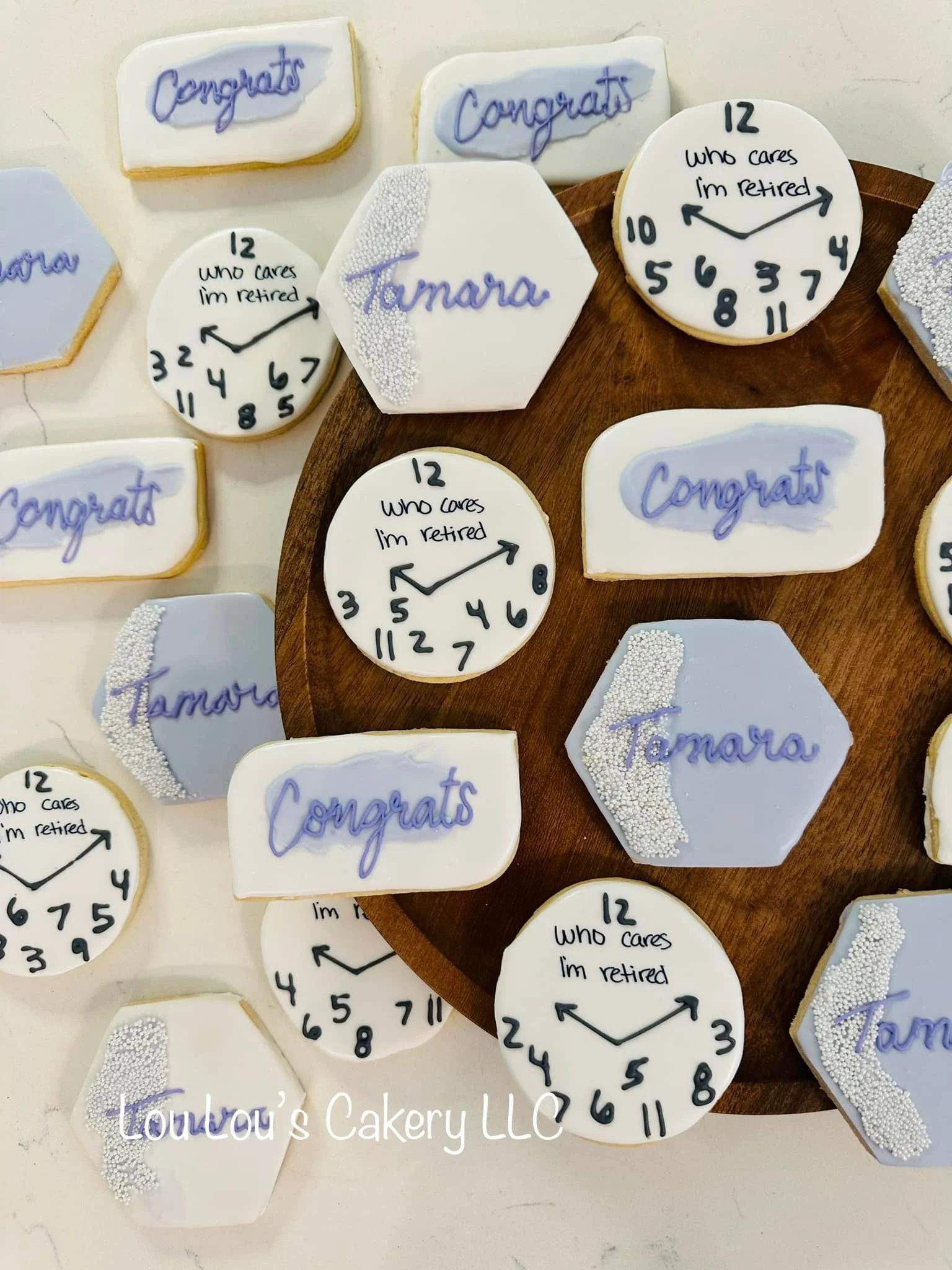 Sugar cookies decorated with congratulatory messages, clock faces, and the name Tamara for a retirement celebration.