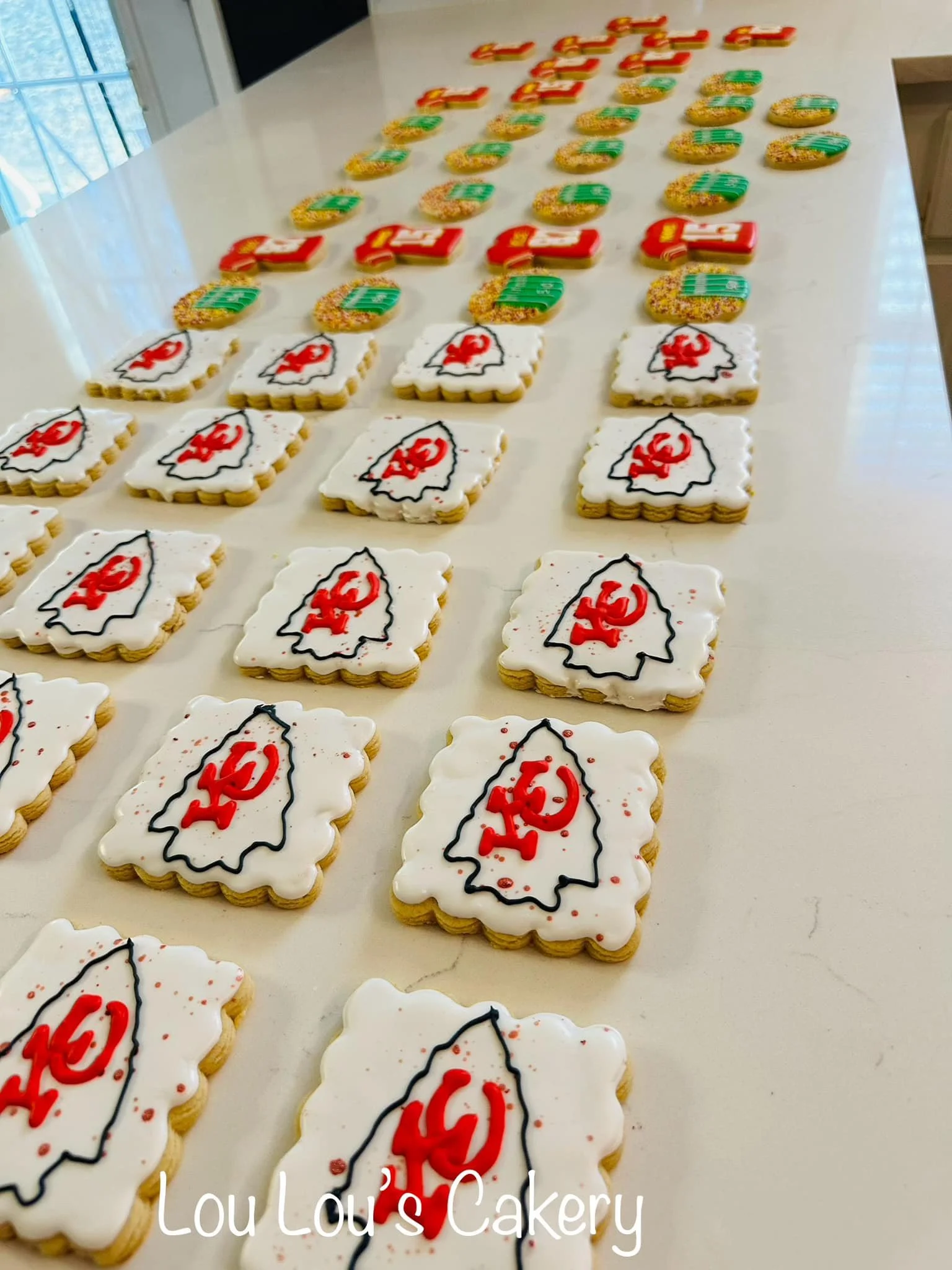 Cookies decorated with the Kansas City Chiefs logo arranged on a table.