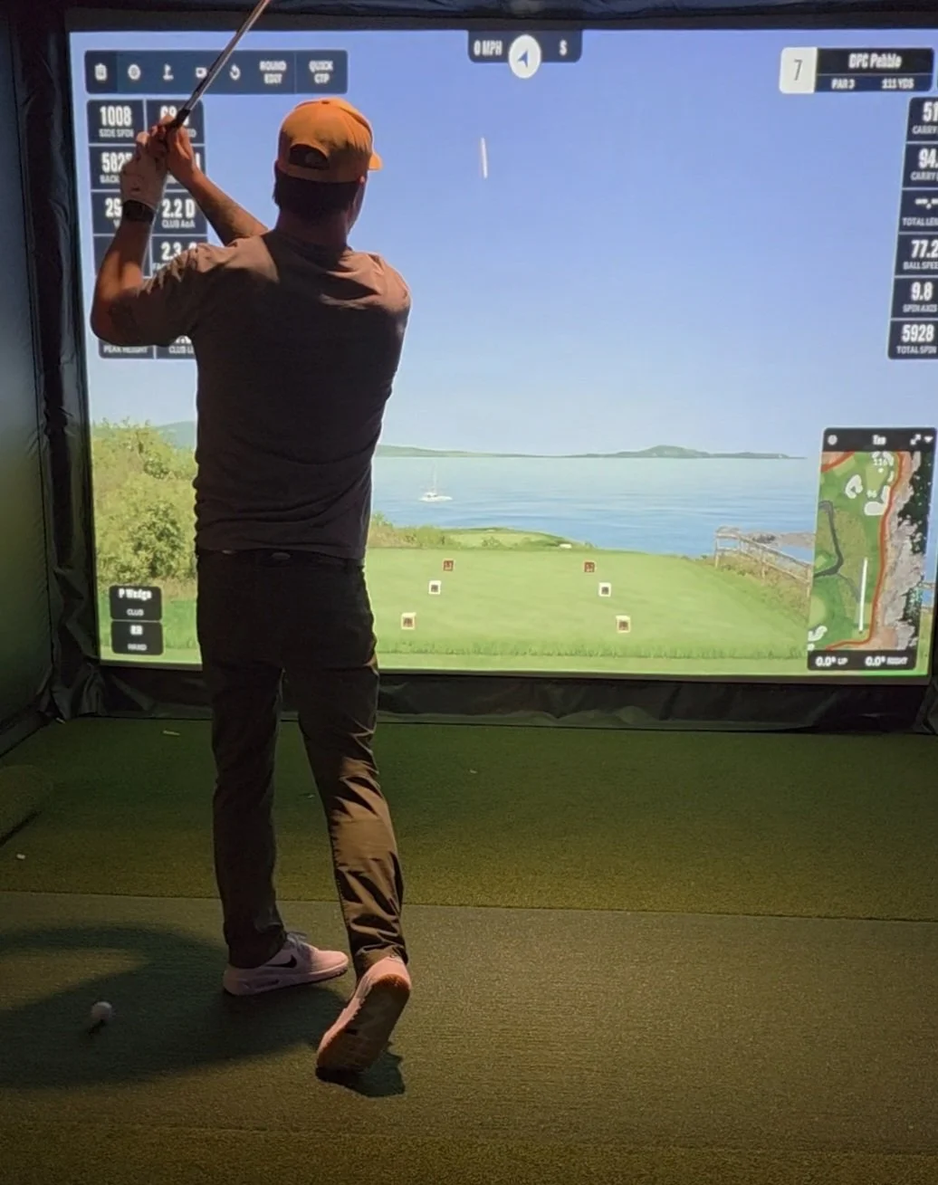 Coach Kary chipping on simulator bay 1