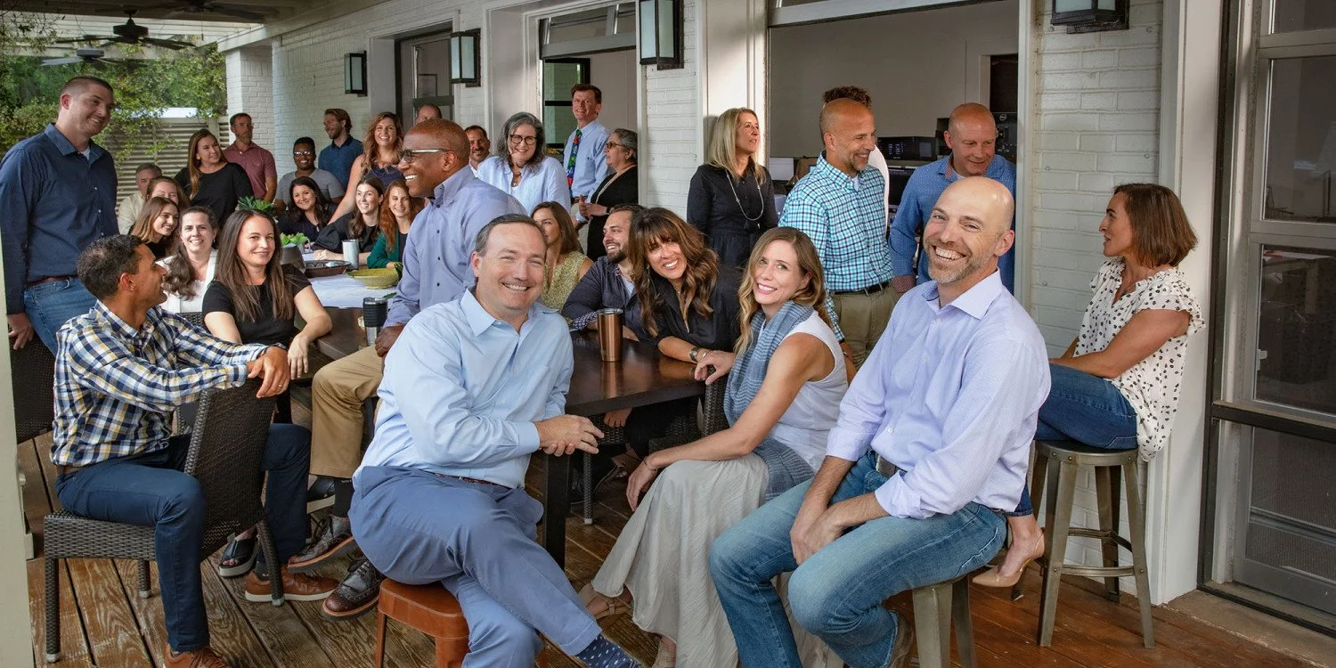 Court Atkins. Architects at Crane Island. Court Atkins Group of diverse adults gathered on an outdoor patio for a social gathering or party, sitting at tables and standing, smiling and engaging with each other.