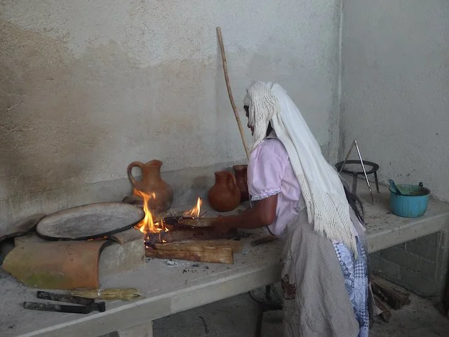Mujer usando comal en cocina de humo, Tavehua, Oaxaca
