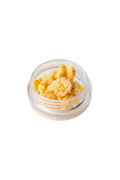 Close-up of a small glass container filled with yellowish cannabis concentrate or wax.