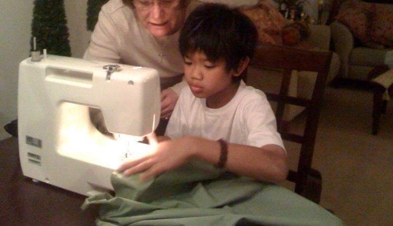 Lorenzo as a child, learning to sew.
