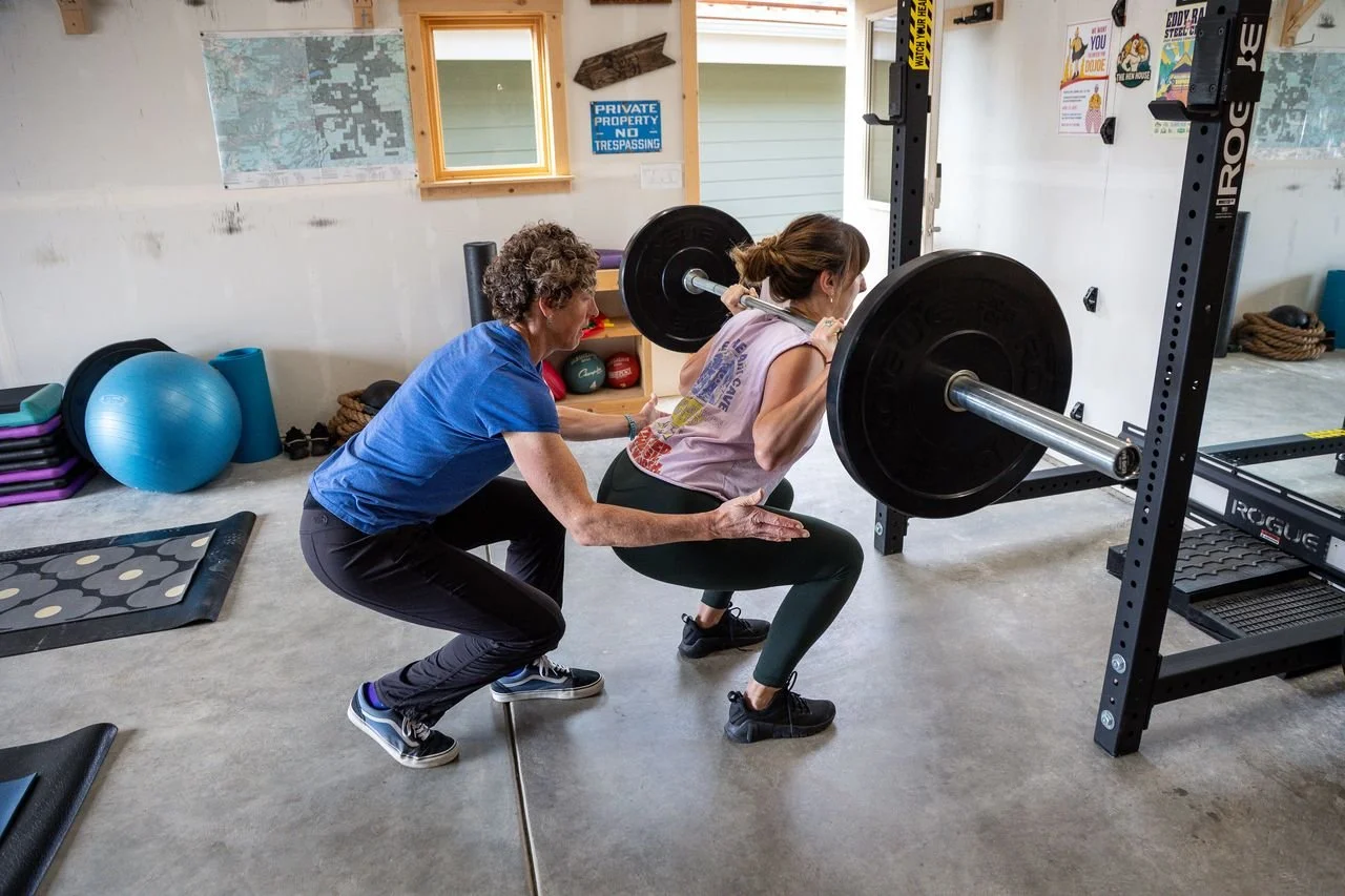 a women squatting with a spotter