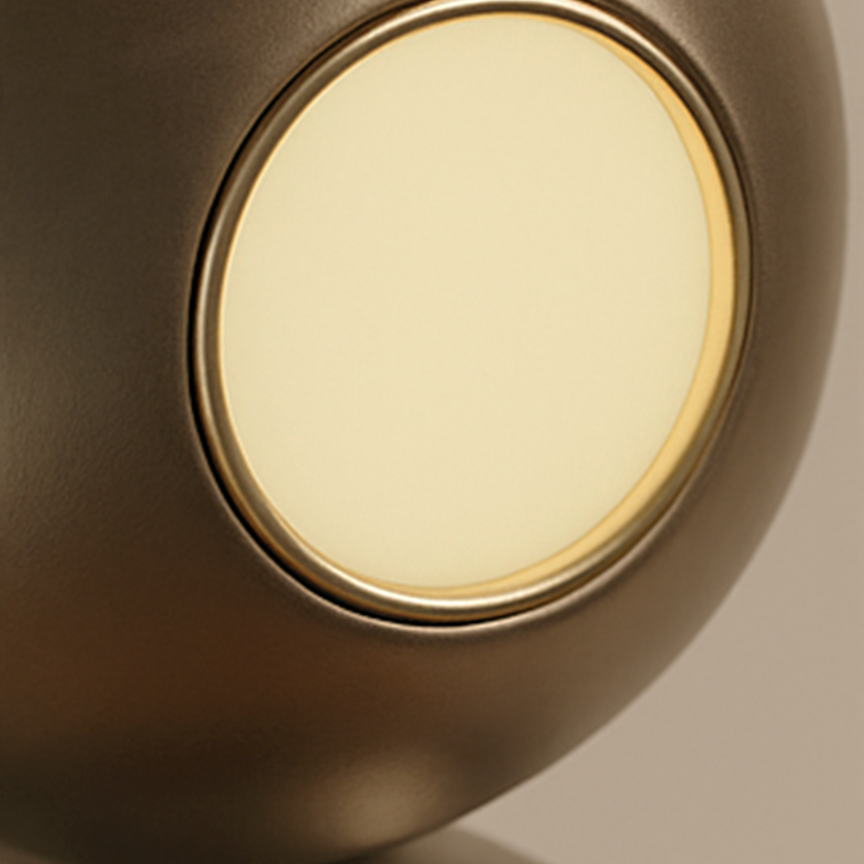 Close-up of a modern, metallic speaker with a glowing front on the left and an open rear port on the right.