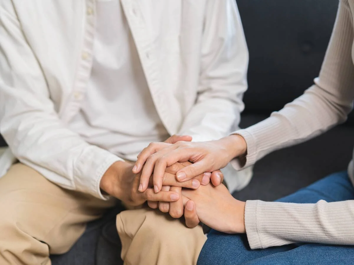 Couple sitting close and holding hands after an emotionally intense conversation