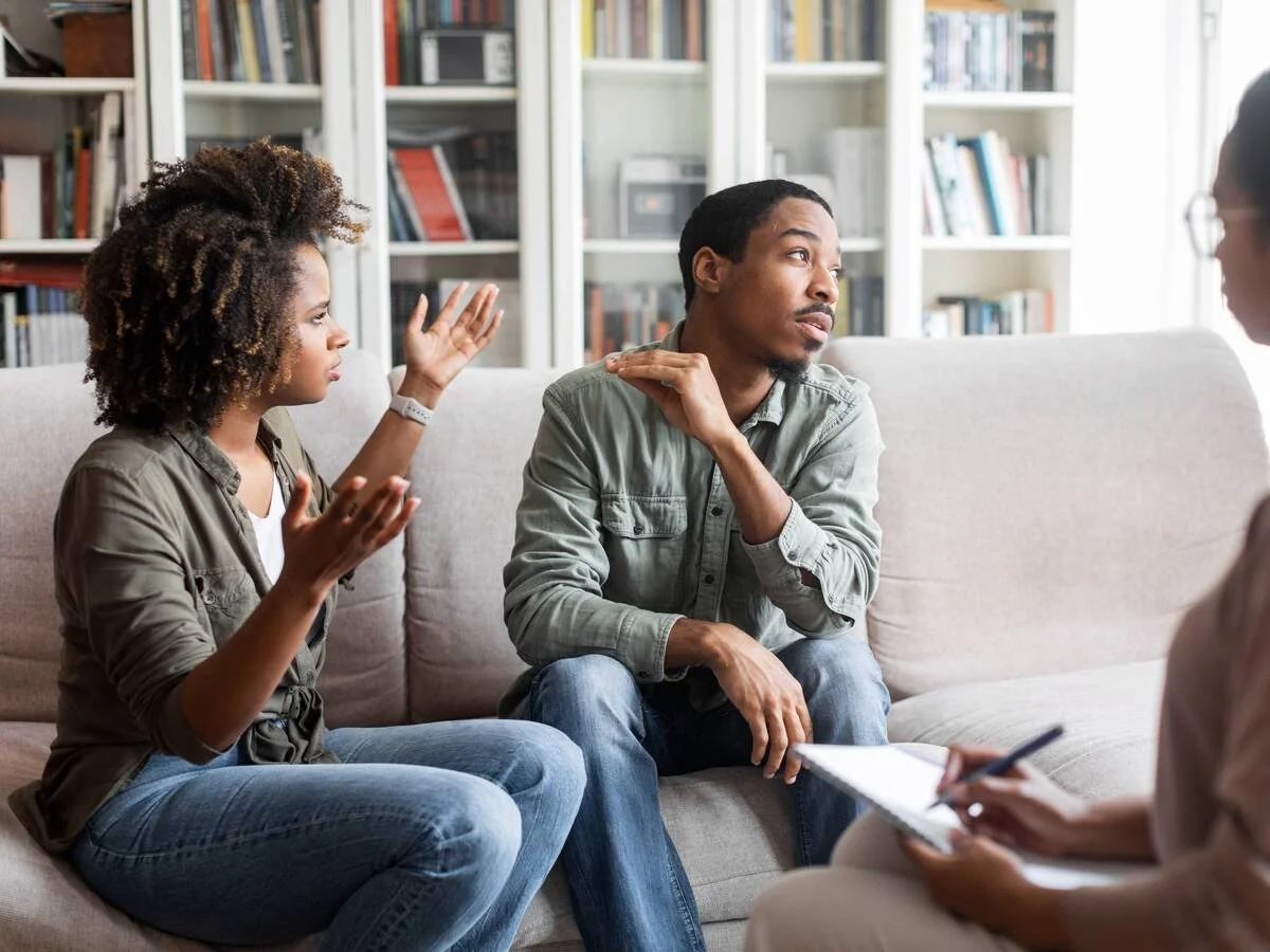 Couple struggling to communicate during a therapy session, showing frustration and distance