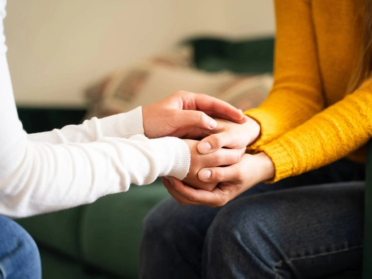 Couple sitting close together after a difficult conversation, showing emotional reconnection