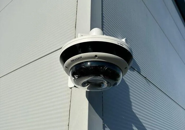 Modern dome security camera installed on commercial building exterior.