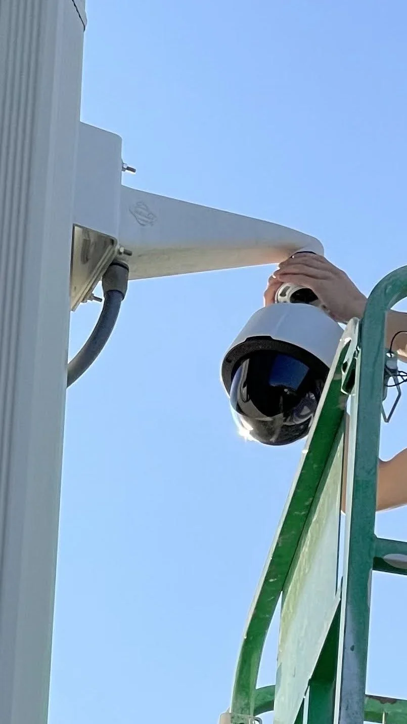 Axis security camera mounted to corner of building