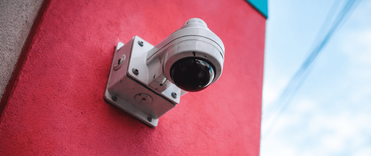 Exterior dome security camera mounted on a commercial building wall for video surveillance and property monitoring