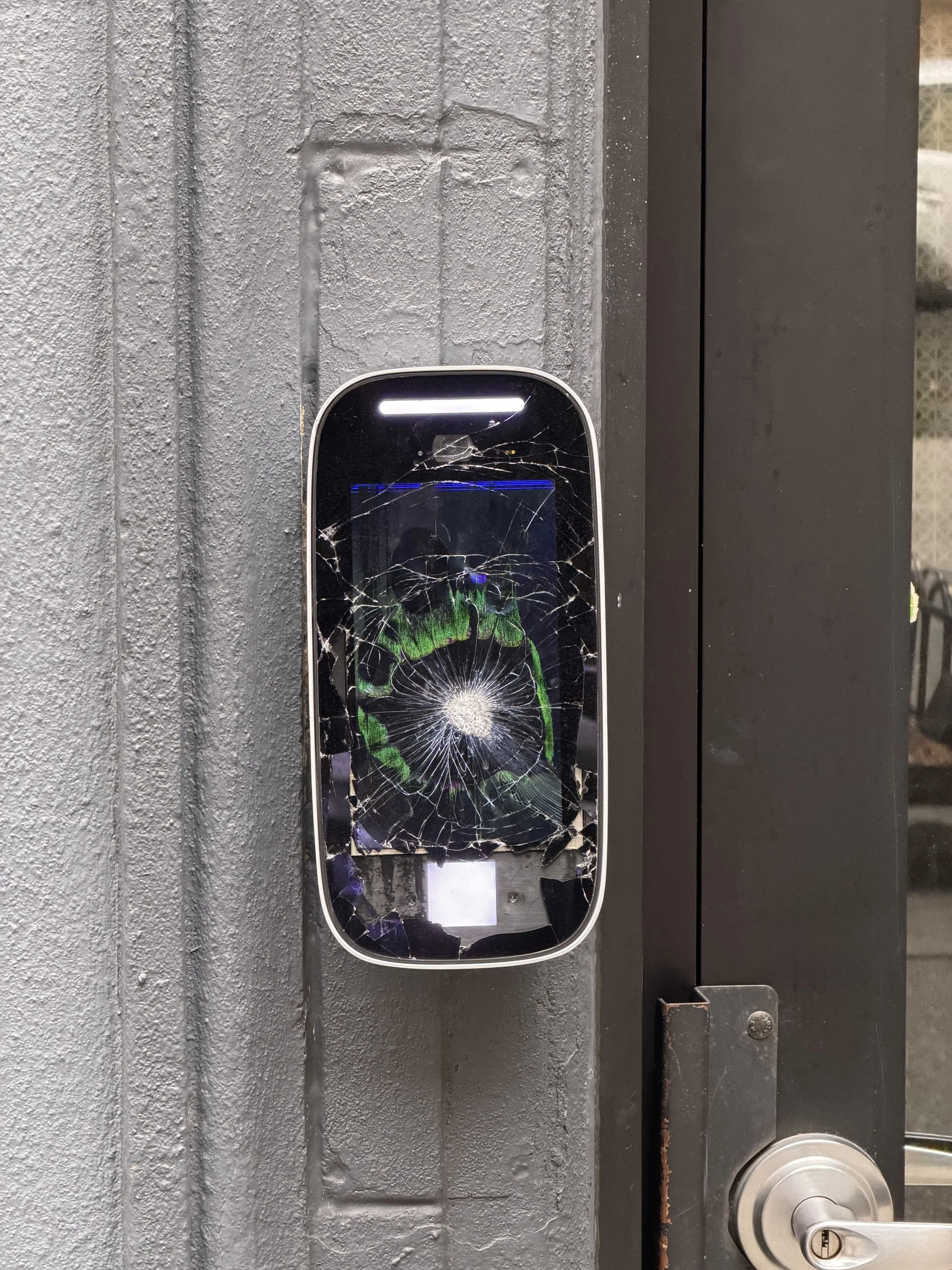 Close-up of broken ButterflyMX intercom screen at NYC building entrance