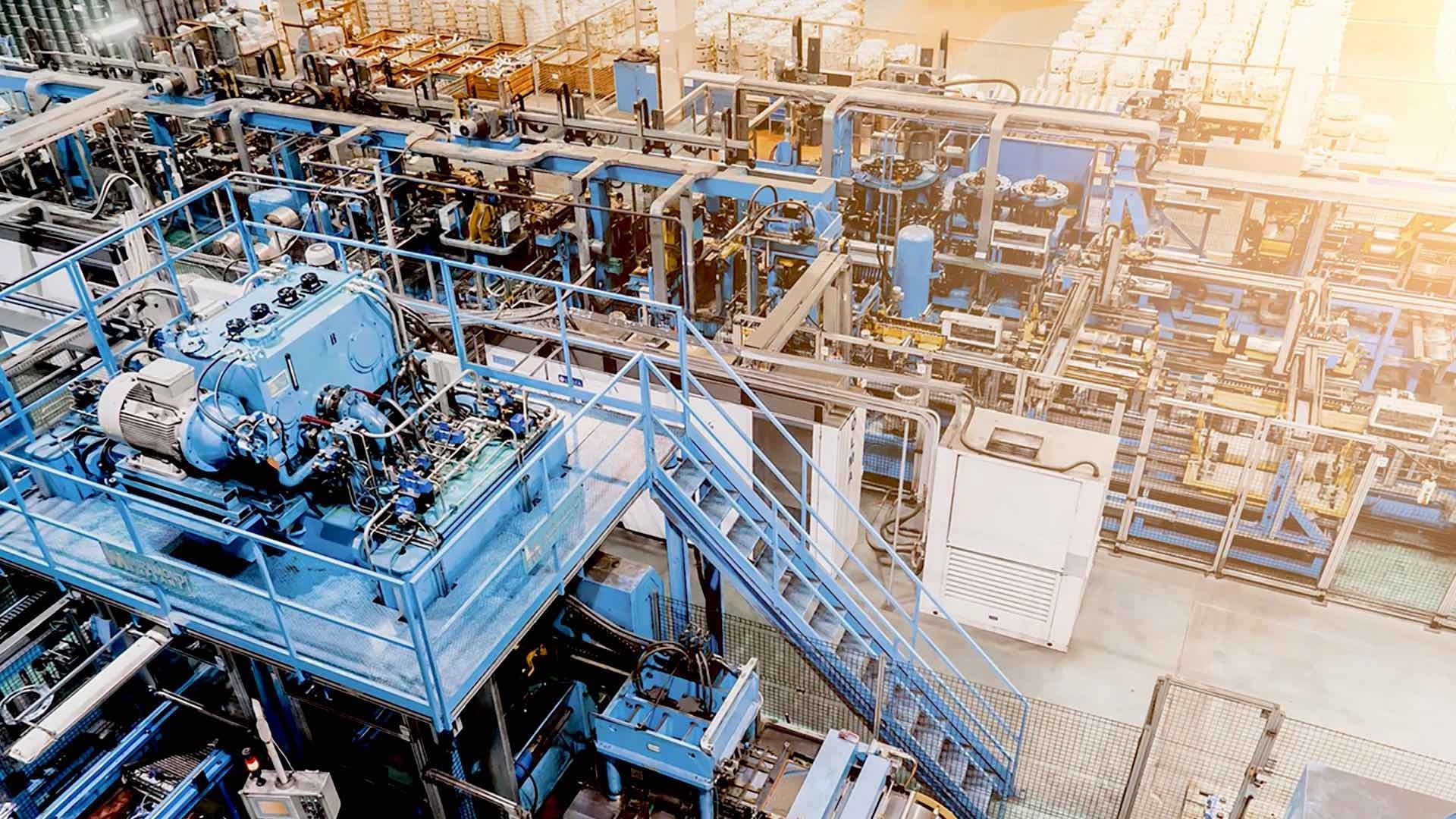 Industrial facility with complex machinery and infrastructure representing integrated security systems for warehouse and logistics monitoring and centralized control