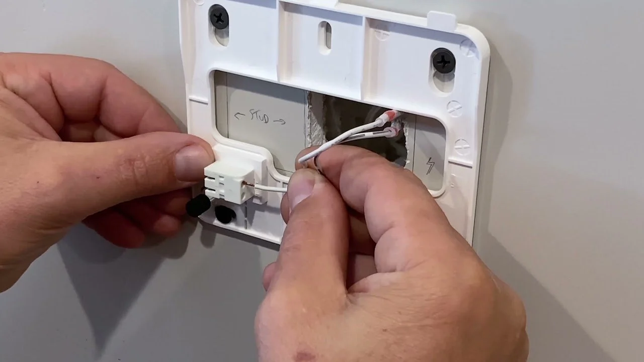 technician wiring Qolsys security panel during professional installation