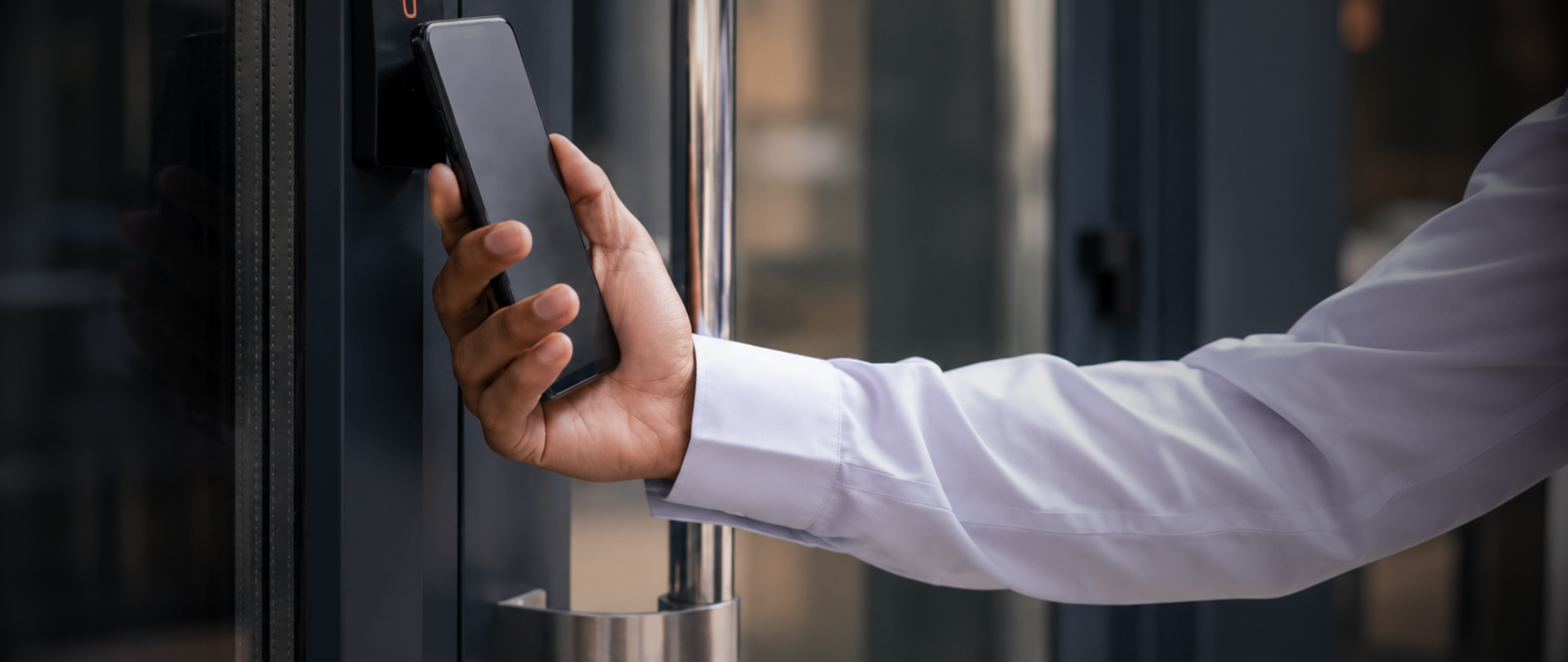 Employee using a smartphone as a mobile credential to access a commercial building through an electronic access control system in Manhattan, NYC.