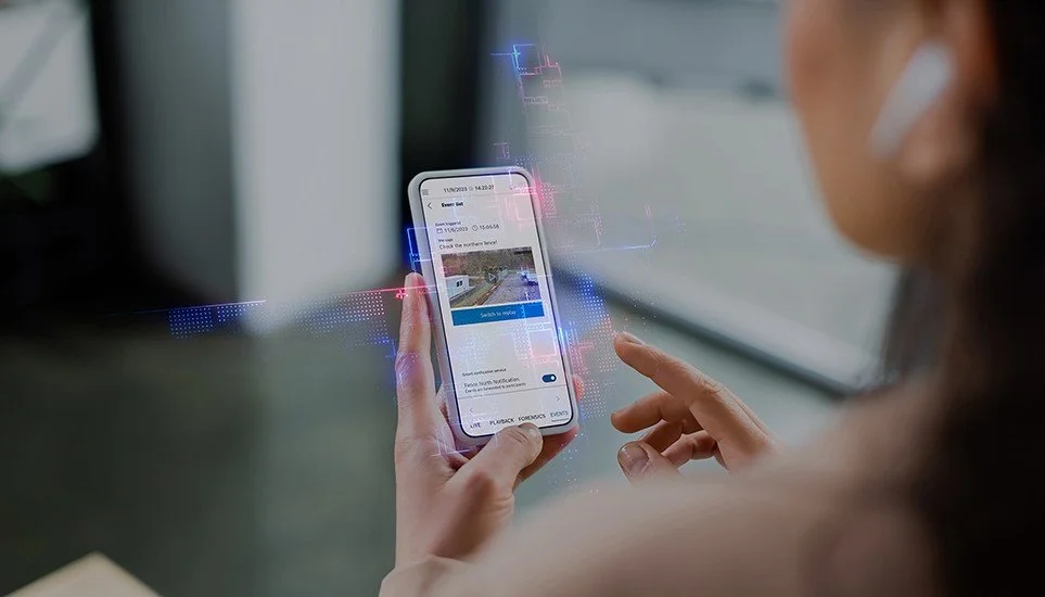 User managing and monitoring a modern Bosch commercial security system through a mobile security app.
