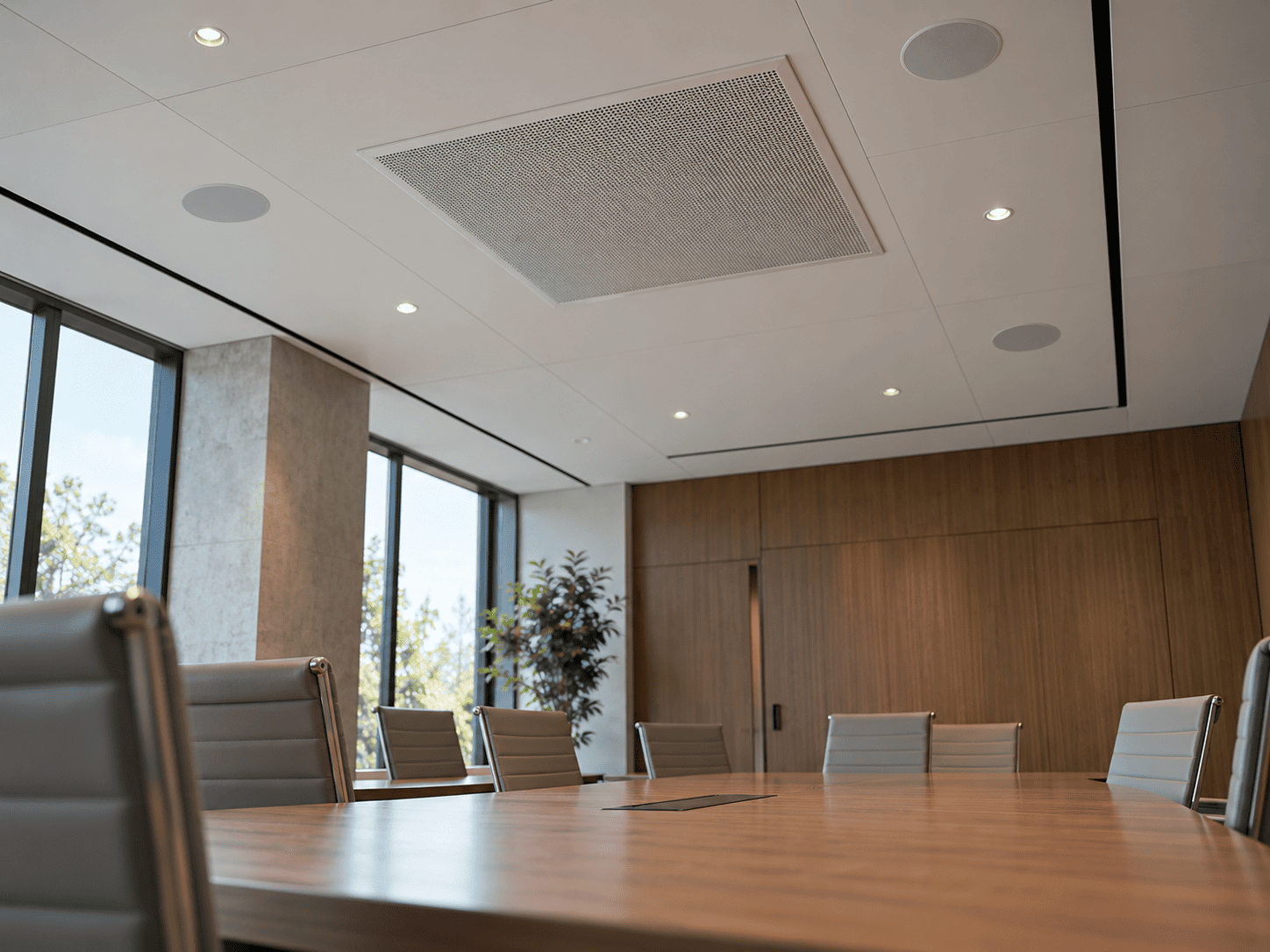 Ceiling microphone array and speakers positioned above a conference table.