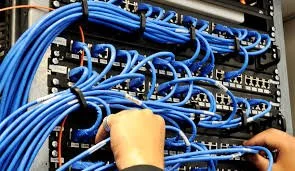 Technician installing structured cabling for physical security system network.