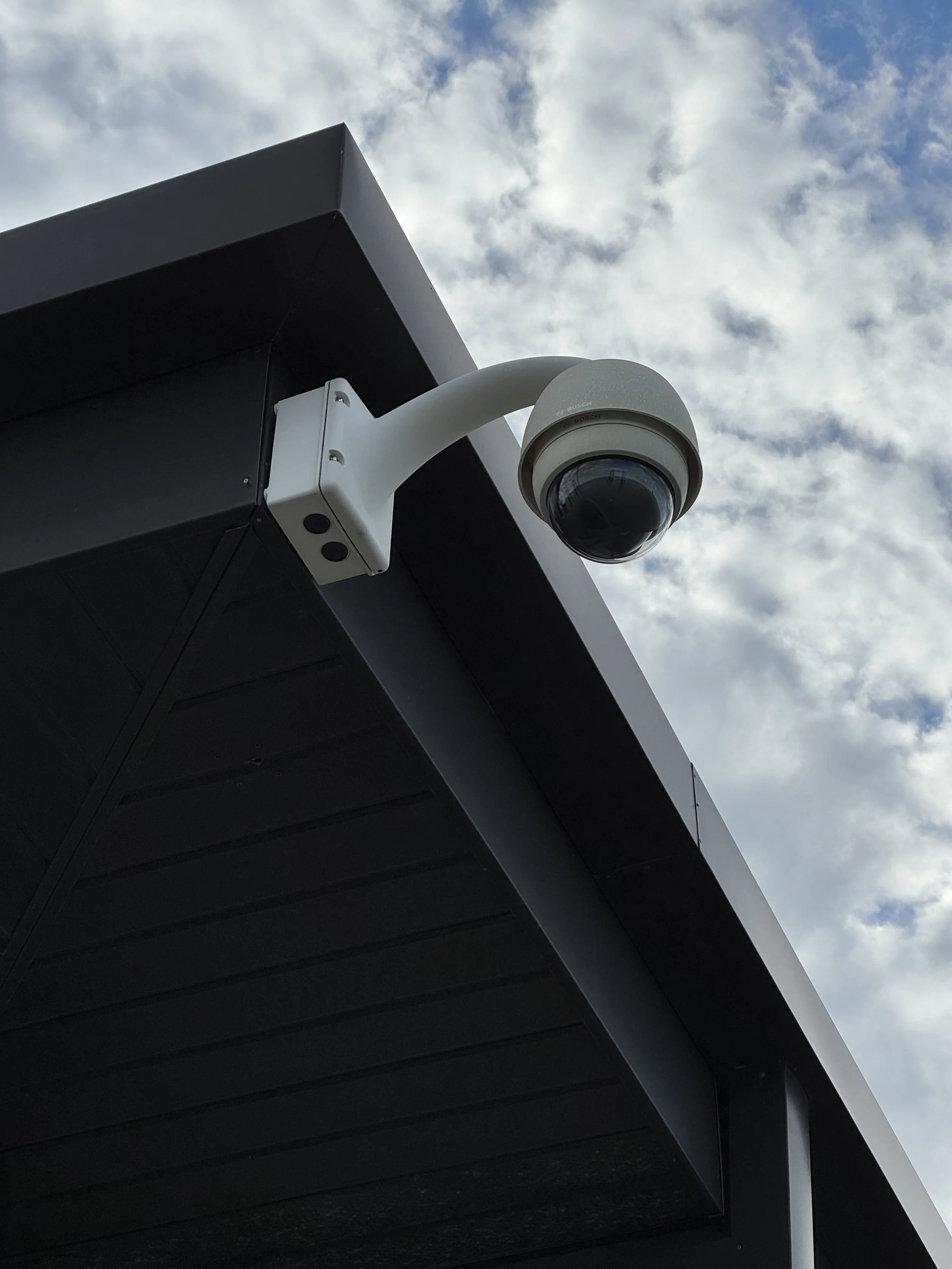 Bosch Security Camera mounted to building, against the sky
