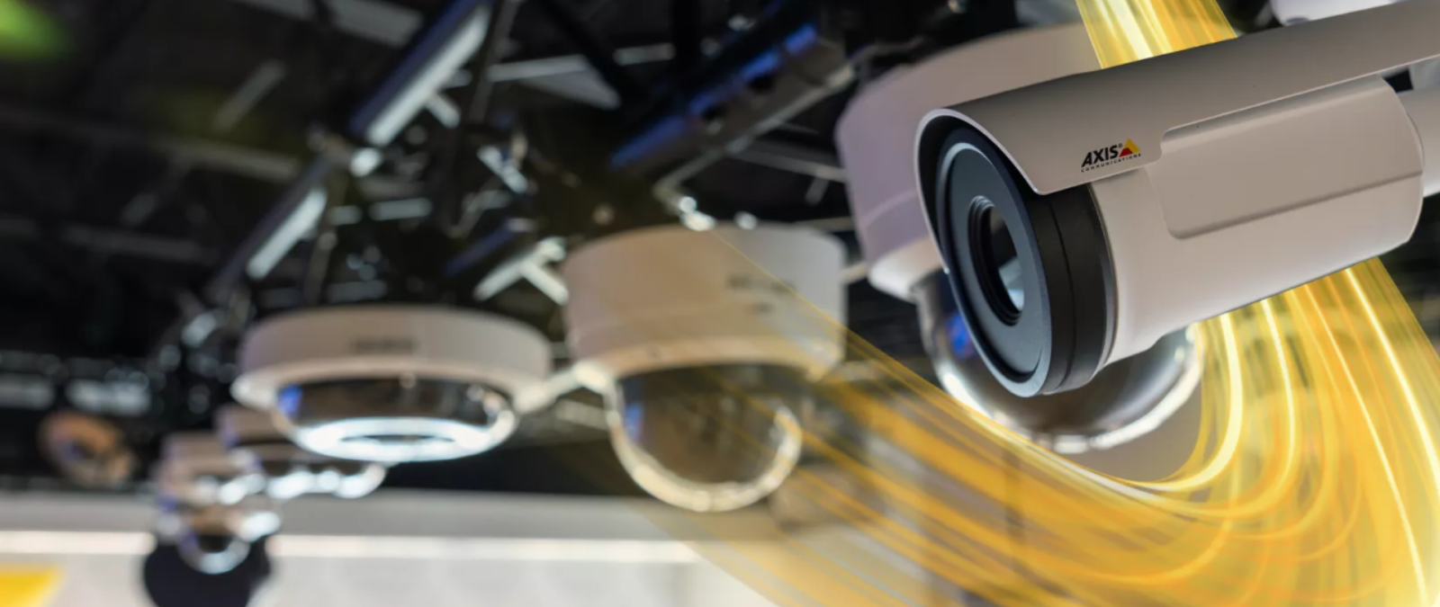 Axis network cameras installed on a ceiling in a commercial environment, showing multiple dome and bullet cameras for surveillance coverage