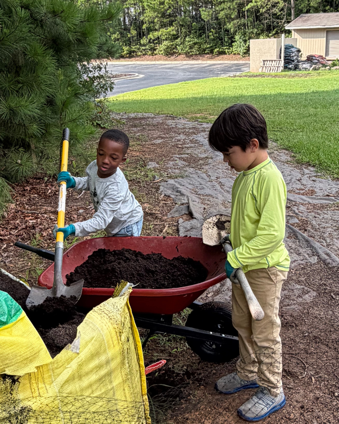 Elementary students engaging in garden work together in The Grove at The Mosaic Field School.