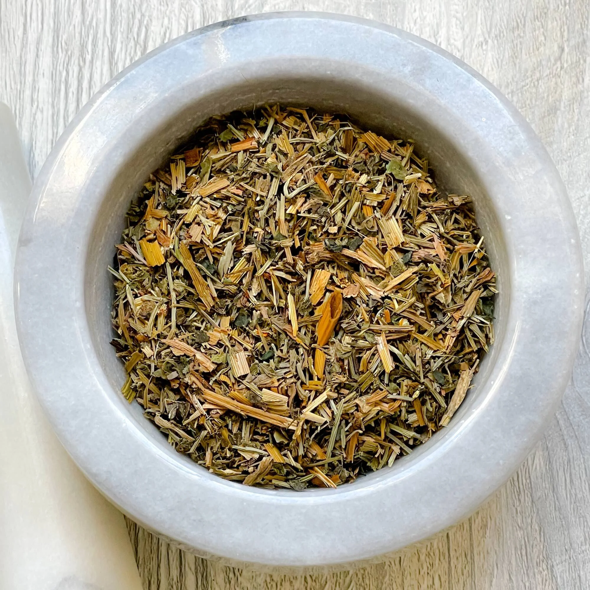 hair-skin-nails-herbal-tea-blend-loose.jpeg: loose hair, skin, and nails herbal tea blend in a mortar
